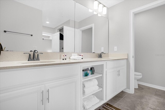 bathroom featuring toilet, vanity, and tile patterned flooring