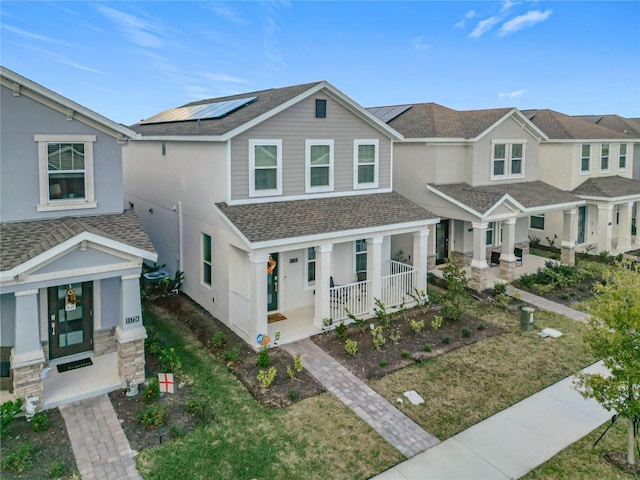 view of front of home with a porch and solar panels