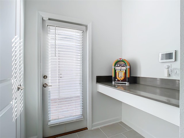 doorway to outside with light tile patterned floors