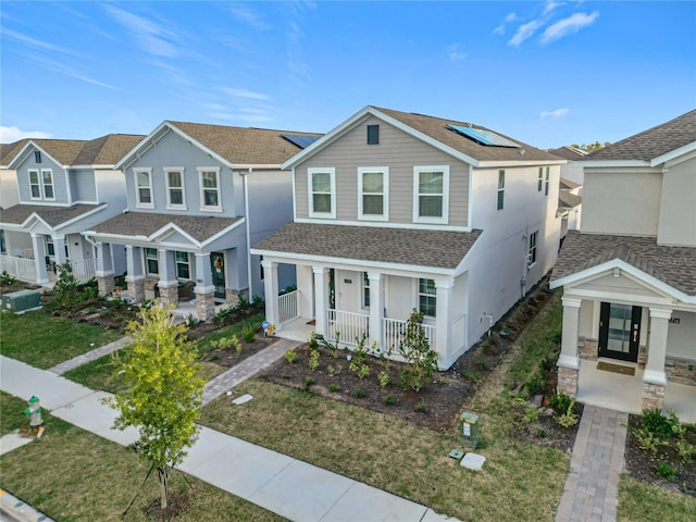 view of front of home featuring covered porch and solar panels