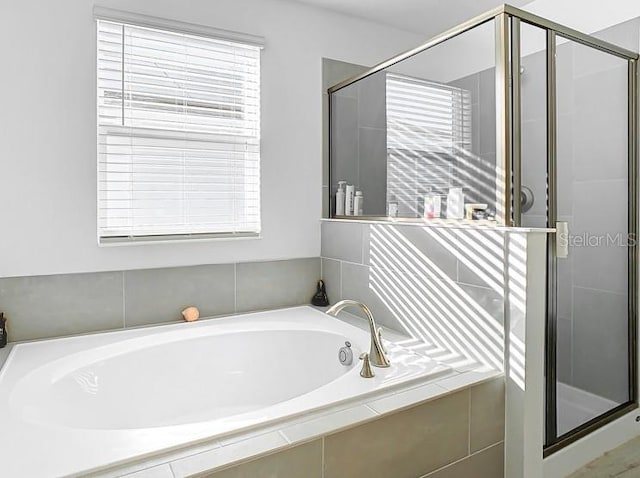 bathroom featuring plus walk in shower and plenty of natural light