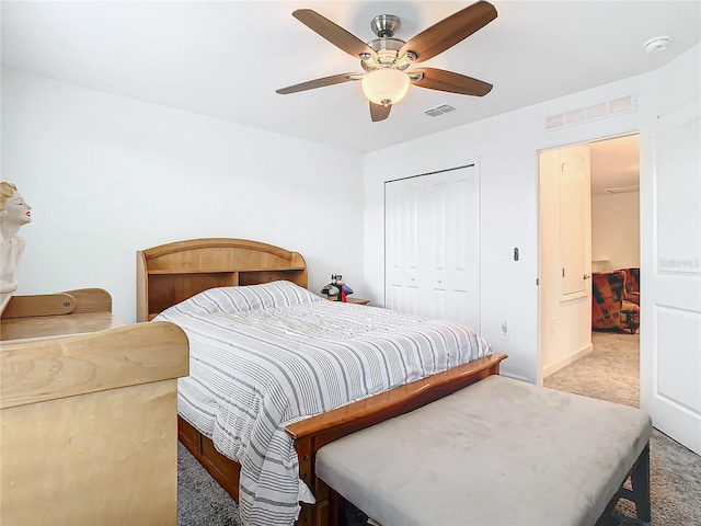 bedroom with ceiling fan, visible vents, a closet, and light colored carpet