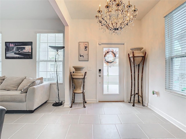 foyer with baseboards, a notable chandelier, and light tile patterned flooring