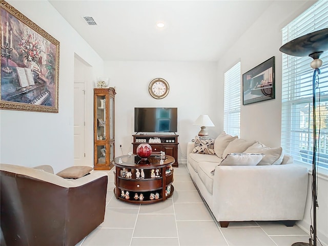 tiled living room with plenty of natural light and visible vents