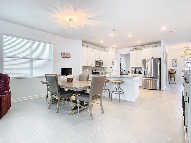 dining space featuring a chandelier, plenty of natural light, visible vents, and baseboards