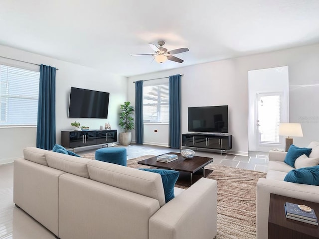 tiled living area featuring a ceiling fan and baseboards