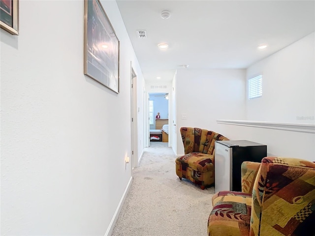 hallway featuring recessed lighting, visible vents, baseboards, and light carpet