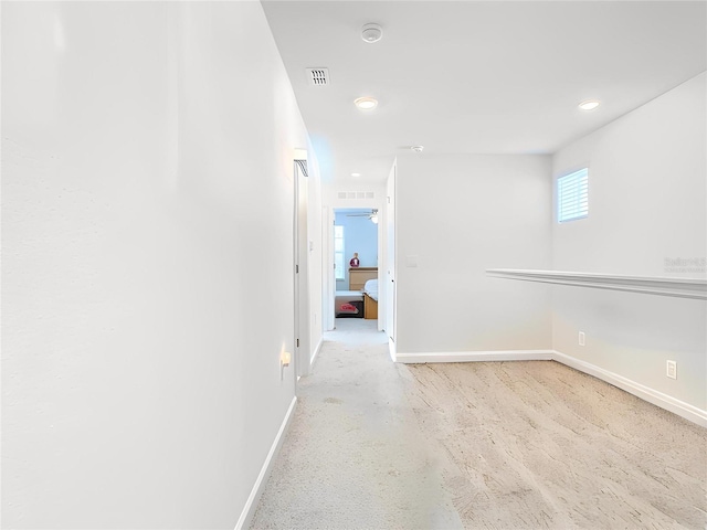 hallway featuring concrete floors, baseboards, visible vents, and recessed lighting