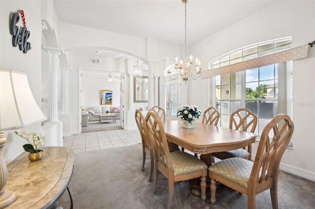 dining area featuring ceiling fan with notable chandelier, light carpet, and decorative columns