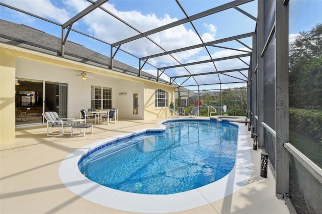 view of swimming pool featuring ceiling fan, a lanai, and a patio