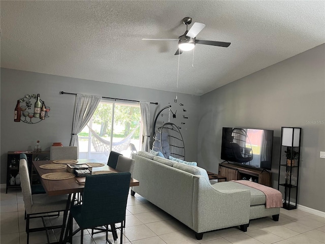 living room featuring ceiling fan, light tile patterned floors, and a textured ceiling