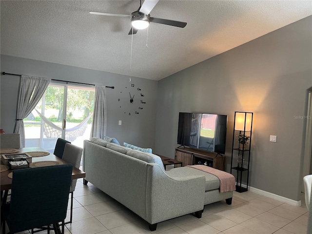 living room with ceiling fan, light tile patterned floors, and a textured ceiling