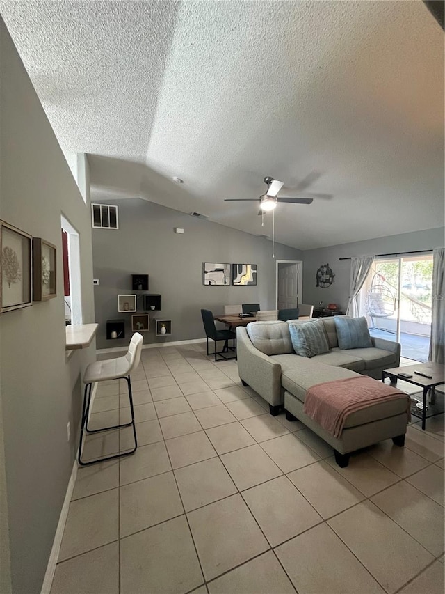 tiled living room featuring a textured ceiling, vaulted ceiling, and ceiling fan