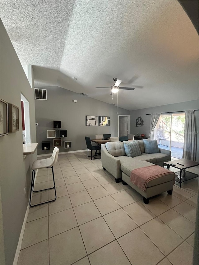 living room featuring light tile patterned floors, a textured ceiling, vaulted ceiling, and ceiling fan