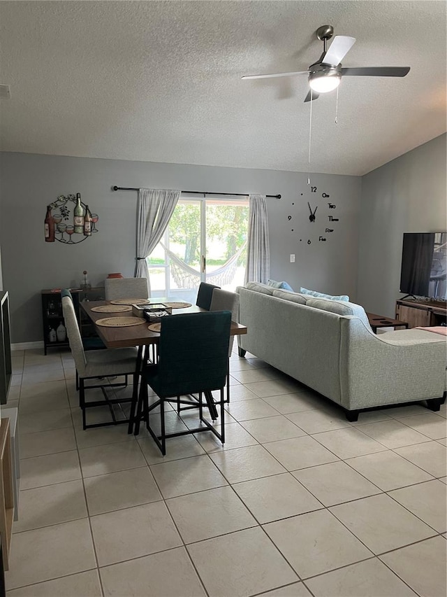 dining room featuring ceiling fan, light tile patterned floors, and a textured ceiling