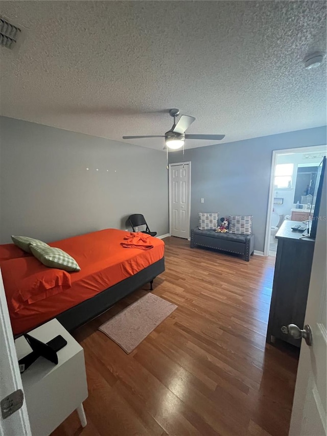 bedroom featuring hardwood / wood-style floors, a textured ceiling, and ceiling fan