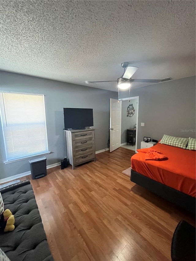 bedroom with a textured ceiling, hardwood / wood-style flooring, and ceiling fan