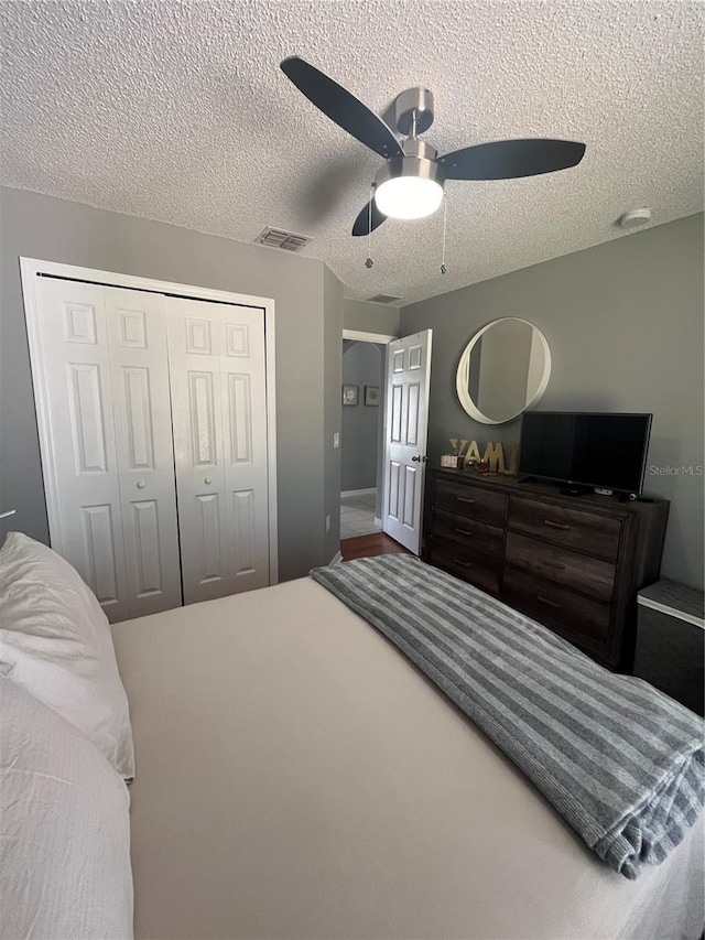 bedroom featuring ceiling fan, carpet floors, a textured ceiling, and a closet