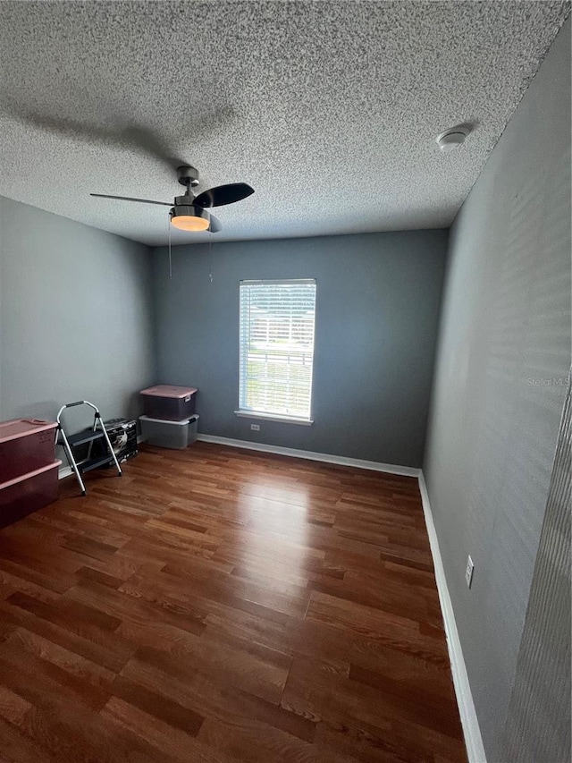 spare room with a textured ceiling, dark hardwood / wood-style floors, and ceiling fan