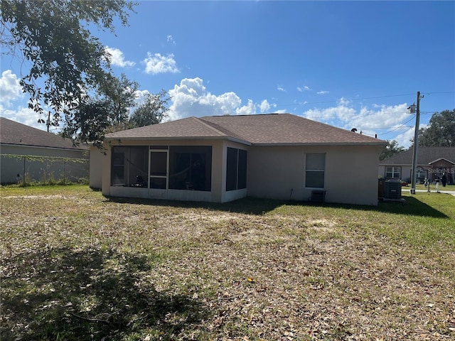 back of property with a lawn and a sunroom