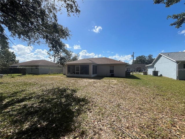 back of property with a lawn and a sunroom