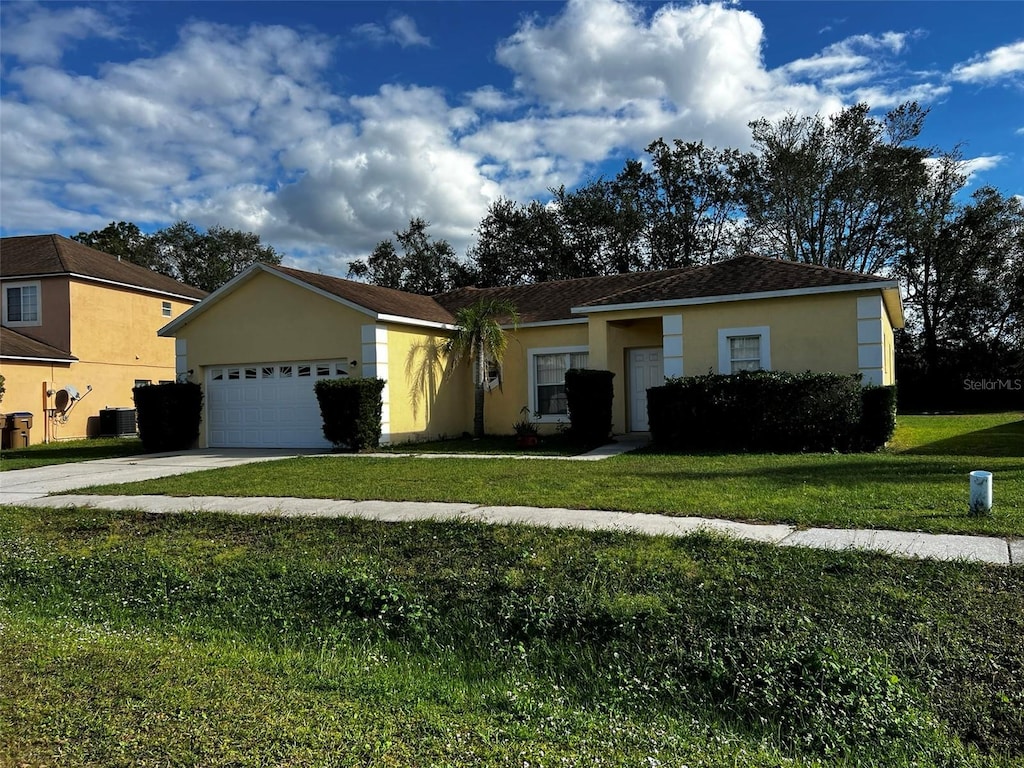 ranch-style home featuring a garage, a front lawn, and central air condition unit