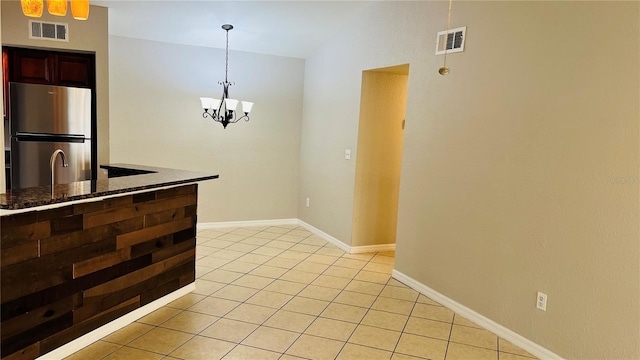 kitchen featuring a chandelier, light tile patterned floors, decorative light fixtures, and stainless steel refrigerator