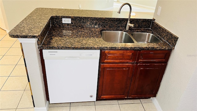 kitchen with white dishwasher, light tile patterned flooring, sink, and dark stone counters