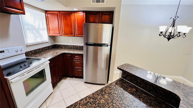 kitchen featuring white range with electric stovetop, pendant lighting, light tile patterned floors, a chandelier, and stainless steel refrigerator