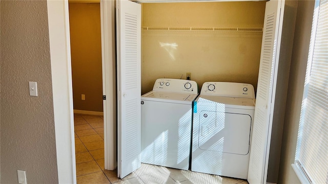 washroom with separate washer and dryer and light tile patterned floors