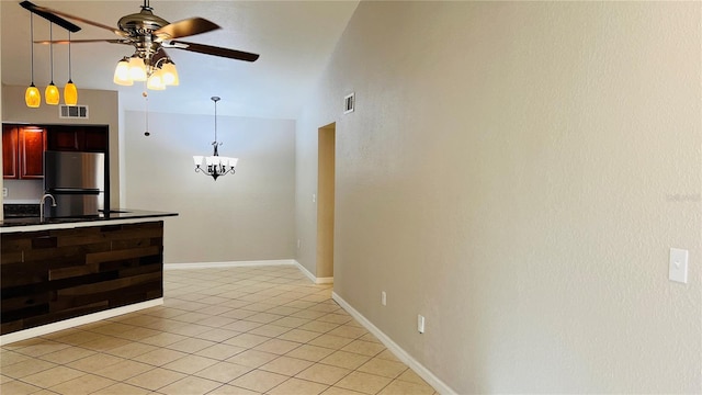 kitchen with stainless steel fridge, ceiling fan with notable chandelier, decorative light fixtures, high vaulted ceiling, and light tile patterned flooring