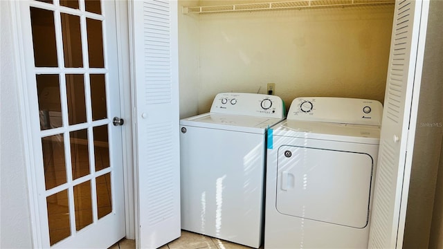 laundry room with separate washer and dryer and light tile patterned flooring