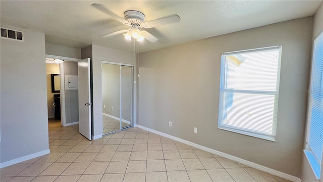 unfurnished bedroom with ceiling fan, a closet, and light tile patterned floors