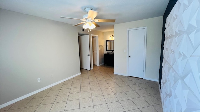 unfurnished bedroom with light tile patterned floors and ceiling fan