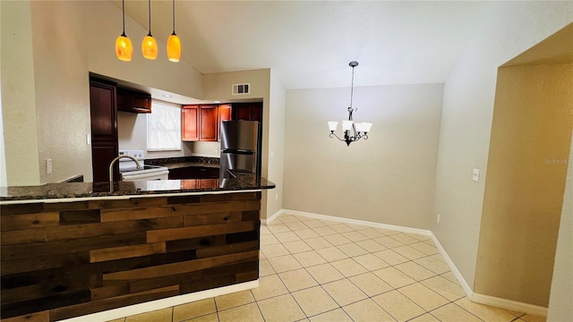 kitchen with kitchen peninsula, vaulted ceiling, decorative light fixtures, white electric range, and stainless steel refrigerator