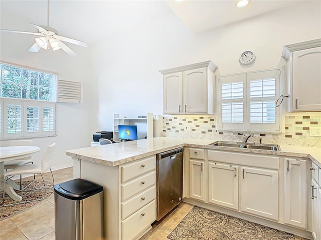 kitchen with kitchen peninsula, decorative backsplash, dishwasher, and sink