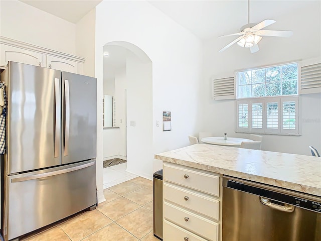 kitchen with cream cabinetry, light tile patterned floors, stainless steel appliances, and ceiling fan