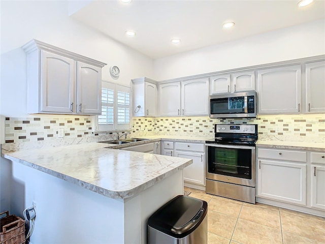 kitchen featuring white cabinetry, sink, kitchen peninsula, light tile patterned floors, and appliances with stainless steel finishes