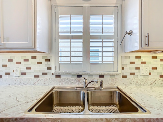 kitchen with white cabinets, backsplash, a wealth of natural light, and sink