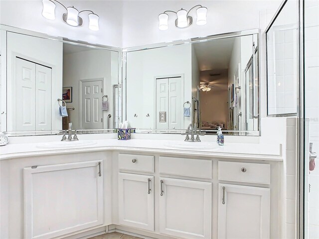 bathroom featuring a shower with door and vanity