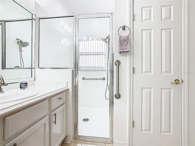 bathroom featuring tile patterned flooring, vanity, and an enclosed shower