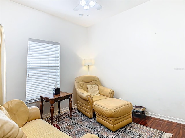 living area with ceiling fan and dark hardwood / wood-style flooring