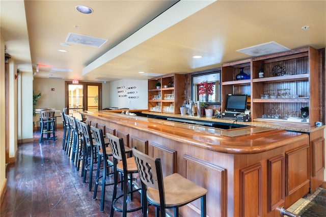 bar featuring dark hardwood / wood-style flooring and wood counters