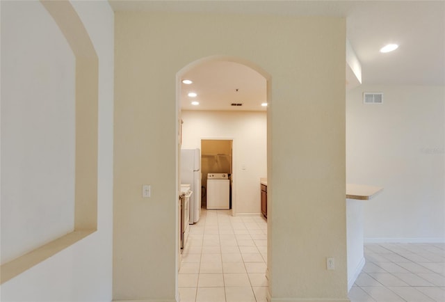 hallway with light tile patterned floors and washer / clothes dryer