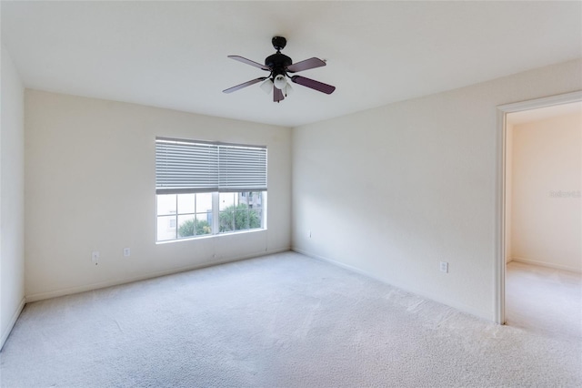 empty room featuring ceiling fan and light carpet