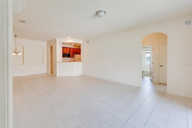 spare room with light tile patterned floors and a chandelier