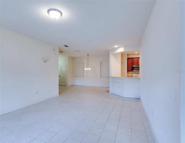 unfurnished living room featuring light tile patterned flooring and an inviting chandelier