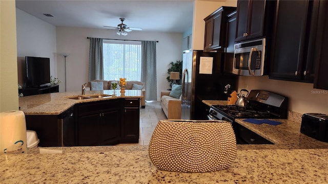 kitchen with ceiling fan, sink, light stone countertops, black electric range, and kitchen peninsula