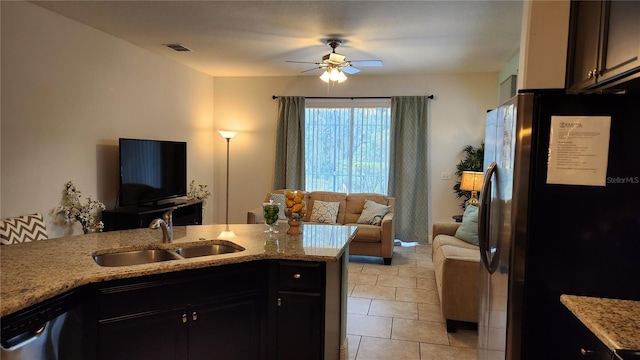 kitchen with ceiling fan, sink, light stone counters, kitchen peninsula, and appliances with stainless steel finishes