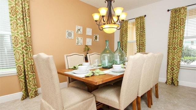 tiled dining space with a wealth of natural light and an inviting chandelier